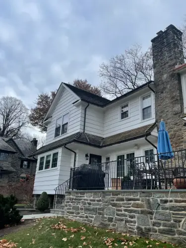 White house with stone patio and chimney