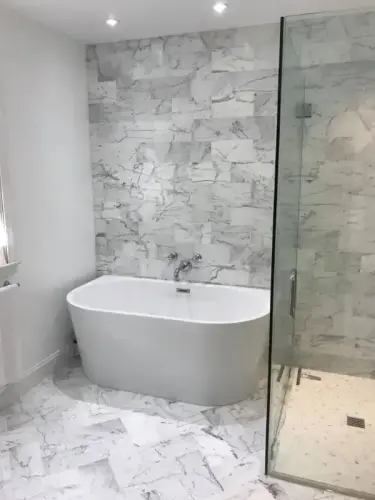 Modern bathroom with marble tiles and bathtub.