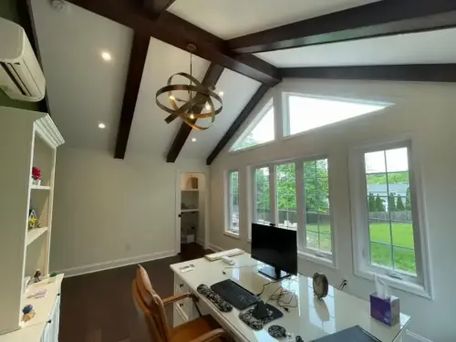 Home office with large windows and lofted ceiling.