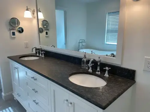 Modern bathroom with double sinks and large mirror.