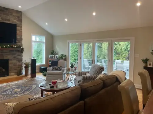 Cozy living room with large windows and fireplace.