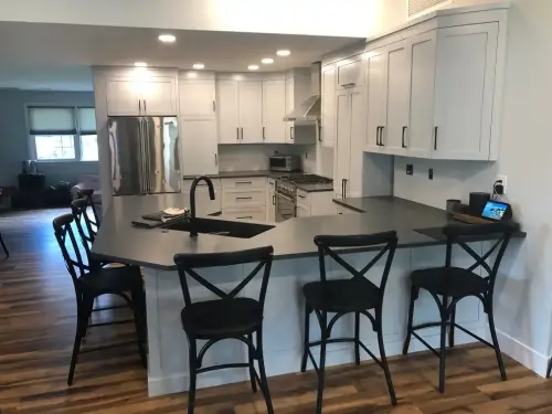 Modern kitchen with white cabinets and island seating.
