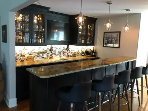 Modern home bar with black stools and backlighting.