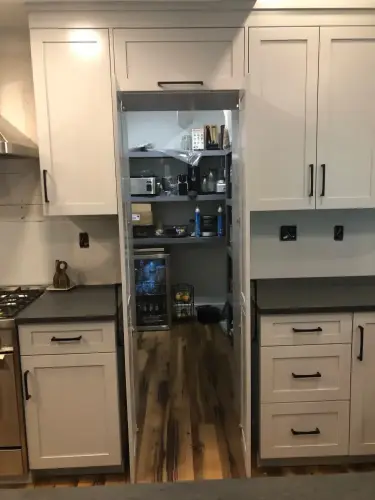 Secret pantry hidden behind kitchen cabinet door.