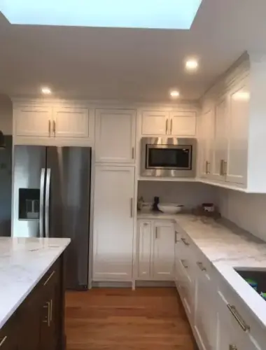 Modern kitchen with white cabinets and appliances.