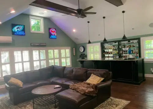 Home bar with leather sofa and neon signs.
