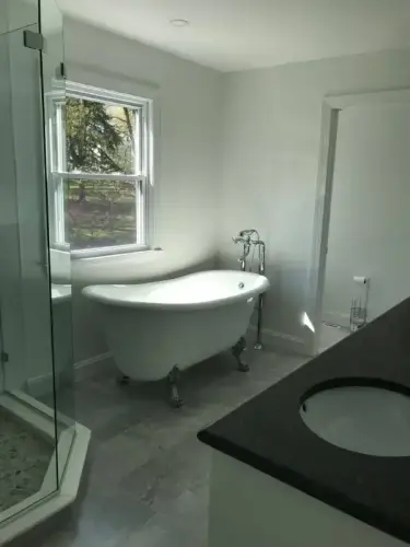 Bright bathroom with clawfoot tub and glass shower