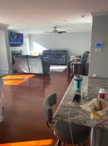 Bright living room with gray couches and kitchen island.