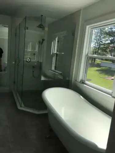 Spacious bathroom with tub and glass shower.