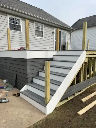 Partially constructed deck with stairs, wood railing added.