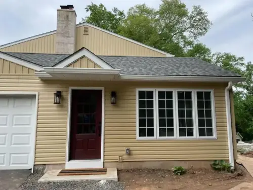 Suburban house with yellow siding and red door.